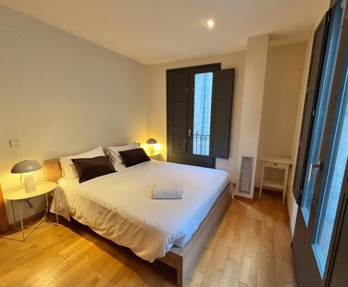 a bedroom with a large white bed and a window at Two bedroom apartment behind the Rambla in Girona