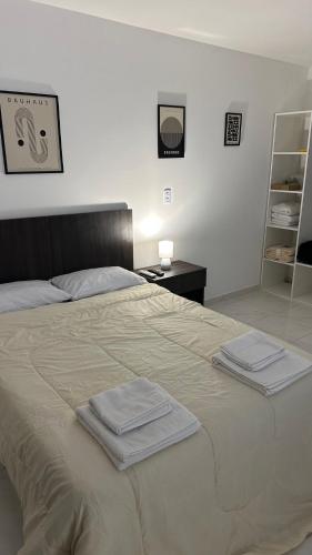 a bedroom with a bed with two towels on it at Norte Urban Suites in Resistencia