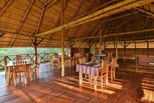 a dining area with tables and chairs in a pavilion at Elephant View Lodge in Kasenyi
