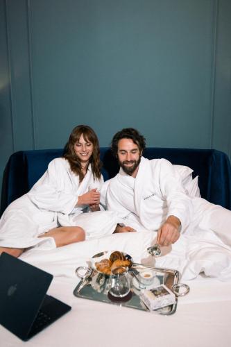 a man and woman sitting on a bed with a plate of food at Casa Laveni in Milan