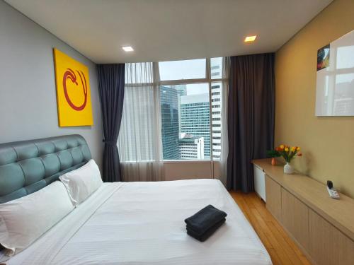 a bedroom with a large bed with a large window at Vortex Residence KLCC by Valen in Kuala Lumpur