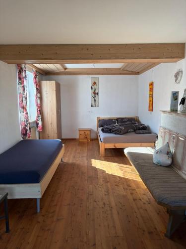 two beds in a room with wooden floors at Ferienwohnung Patrycja in Weissenbach am Lech