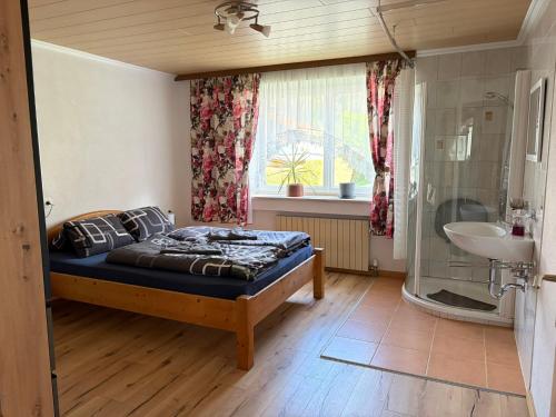 a bedroom with a bed and a sink and a window at Ferienwohnung Patrycja in Weissenbach am Lech