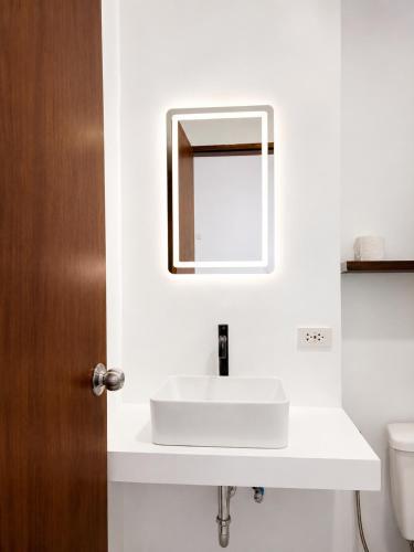 a bathroom with a white sink and a mirror at Hideout Siargao in General Luna