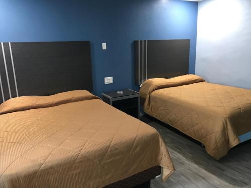 2 camas en una habitación con paredes azules en Empire Inn en Los Ángeles