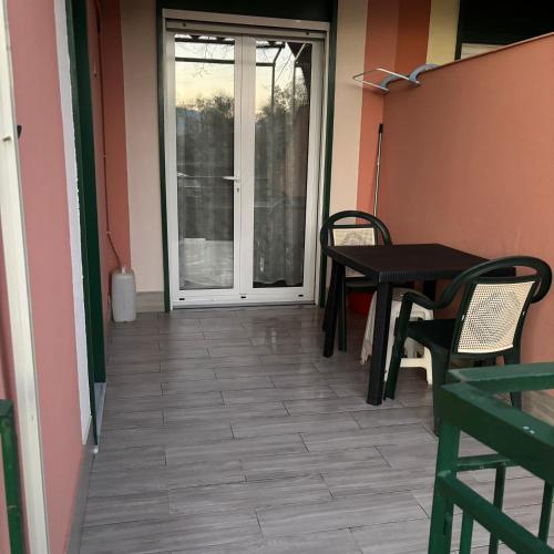 a patio with a table and chairs and a door at Nido di Pace in Giardini Naxos