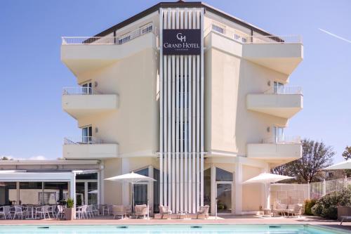 a hotel with a pool in front of it at Grand Hotel in Forte dei Marmi