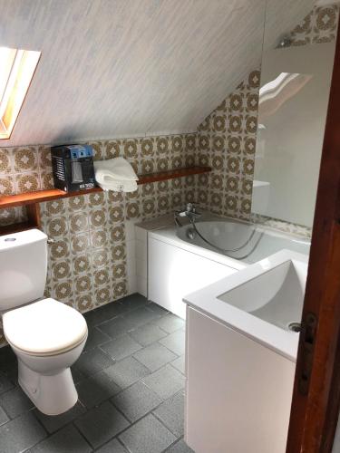 a bathroom with a toilet and a tub and a sink at Cozy apartment in Germainville