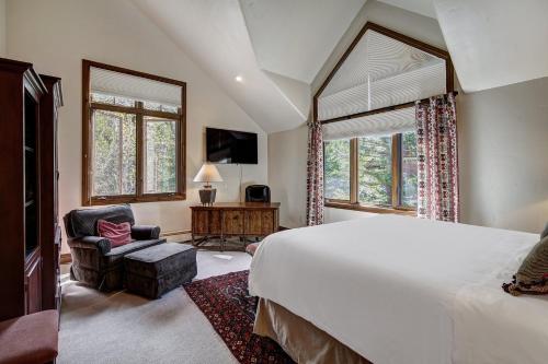 a bedroom with a large white bed and a chair at Arrowhead Village, A Vail Resorts Property in Edwards