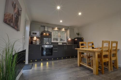 a kitchen and dining room with a table and chairs at Muck in Oban