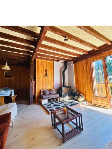 a living room with a table and a fireplace at Chalet individuel 11 personnes in Font-Romeu