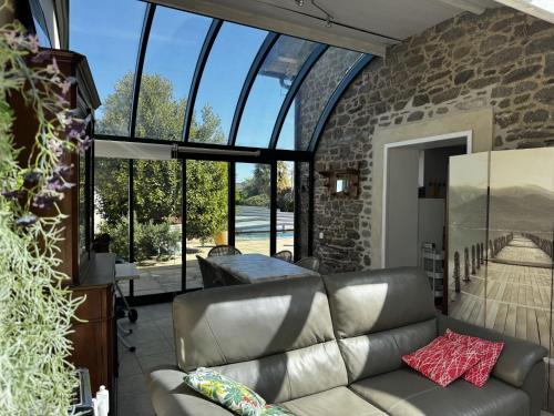 a living room with a leather couch and large windows at Holiday Home La houle by Interhome in Cancale