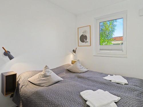 a bedroom with a bed with white towels on it at Apartment Seewind by Interhome in Lembruch