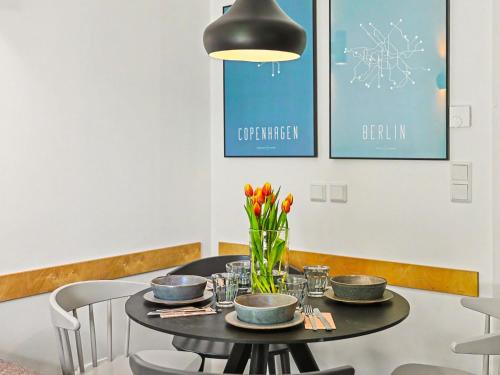 a black table with a vase of flowers on it at Apartment Seewind by Interhome in Lembruch