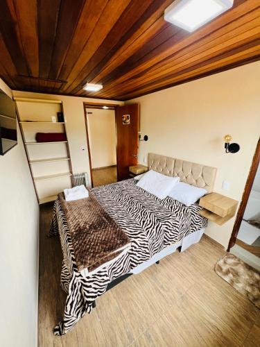 a bedroom with a zebra print bed in a room at Vista das Montanhas in Monte Verde
