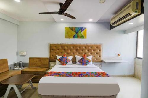 a bedroom with a large bed and a table at FabHotel Backstreet, Bhopal Railway Station in Bhopal