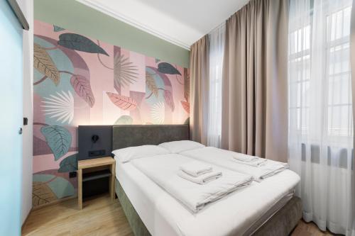 a bedroom with a bed and a wall with plants at NEU - Sona Design Rooms - CITY CENTER - in Bamberg