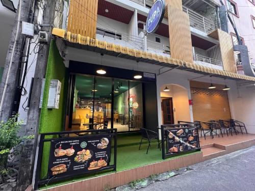 a restaurant with a sign in front of a building at Pupa Rooms in Patong Beach