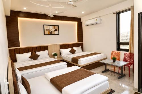 a hotel room with two beds and a table at Hotel Shree Radhe Mohan And Resort in Khātu