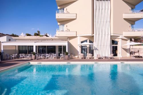 a swimming pool in front of a building at Grand Hotel in Forte dei Marmi