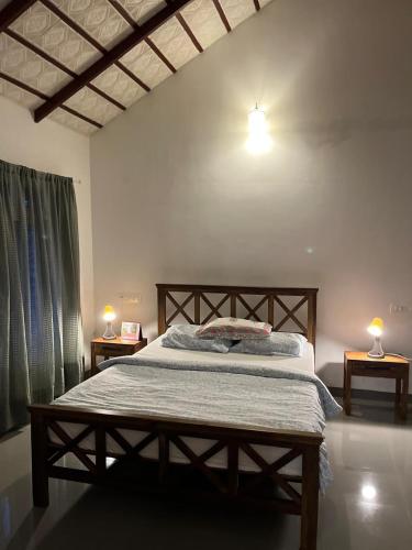 a bedroom with a bed with two lamps on two tables at Birdsong Coffee Estate Stay in Madikeri