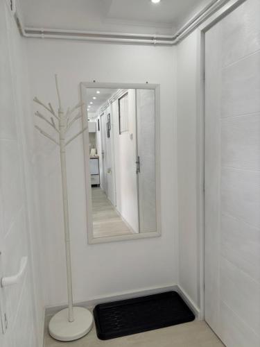 a white bathroom with a mirror and a floor rug at Diamond apartment in Kikinda