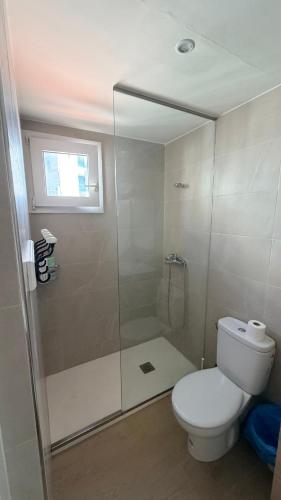 a bathroom with a toilet and a glass shower at Apartamentos Lin in Lloret de Mar