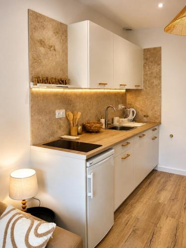 a kitchen with white cabinets and a sink at Casa Luna in Saint-Chamond