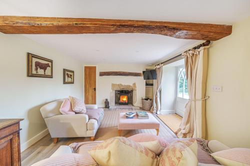 a living room with a couch and a fireplace at Puddle Cottage in Dorchester