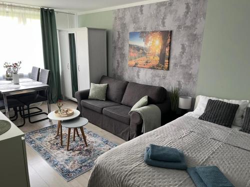 a living room with a bed and a couch at Apartament Piaskowa Mountain & Coffee in Wałbrzych