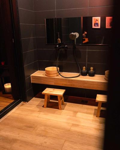 a bathroom with a shower and a bench and a sink at Somn'en Bulle in Najac