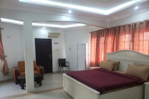 a bedroom with a bed and a desk and a chair at Edo Global Boutique apartment in Benin City