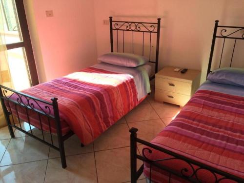 a bedroom with two beds in a room with a window at affittacamere casaGiarelli&Battistini in Monti di Licciana Nardi