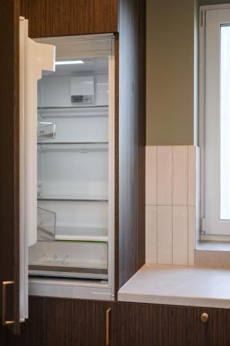 an empty refrigerator with its door open in a kitchen at ММ GROUP APARTMENT in Uzhhorod
