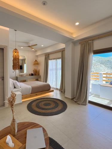 a bedroom with a bed and a large window at Spongia Apartments and Suites Kalymnos in Kalymnos