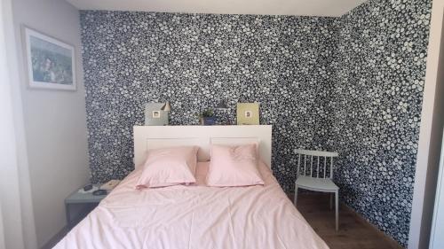 a bedroom with a bed with a floral wallpaper at HOLIDAYLAND BAIE DES OLIVIERS VILLA 36m2 1chambre fermée 6 couchages ou VILLA 41M2 2chambres fermées 7 couchages in Narbonne-Plage