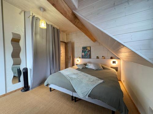 a bedroom with a bed in a attic at L Écrin de Jade Maison de Bourg La MENITRE in La Menitré