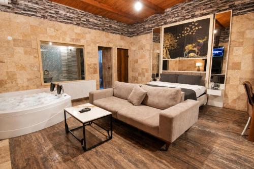 a living room with a couch and a bed and a tub at 216 North Hotel in Ağva