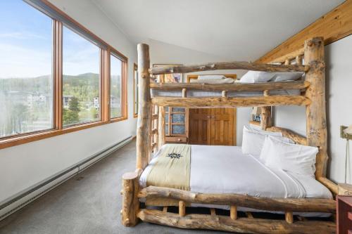 a bedroom with two bunk beds in a room with windows at Evergreen Condominiums by Vail Resorts in Keystone