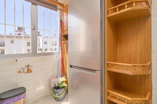 a refrigerator in a kitchen with a window at Vivienda junto a Plaza España in Nerja