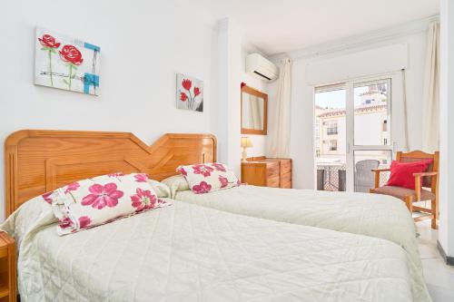 a bedroom with two beds and a window at Vivienda junto a Plaza España in Nerja