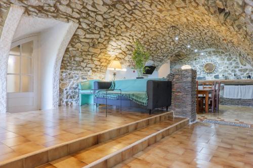 a room with a table and a stone wall at Le Mas Boyer in Chauzon