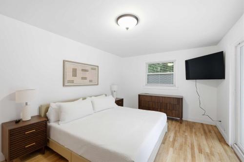 a white bedroom with a bed and a television at Mason Ranch - Game Room in Mason