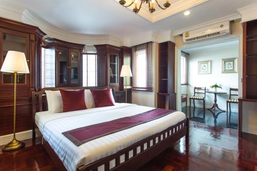 a bedroom with a large bed with red pillows at The Lek Aree in Bangkok