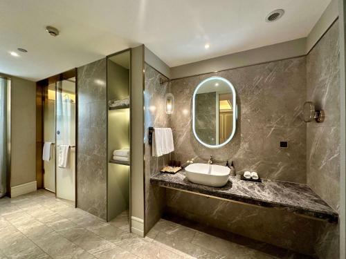 a bathroom with a sink and a mirror at Mercure Xian City Centre in Xi'an