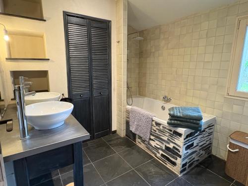 a bathroom with a sink and a tub and a toilet at L Écrin de Jade Maison de Bourg La MENITRE in La Menitré
