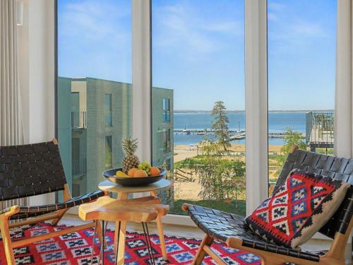 a room with two chairs and a table with a bowl of fruit at Apartment Penthouse Seevibes by Interhome in Lembruch
