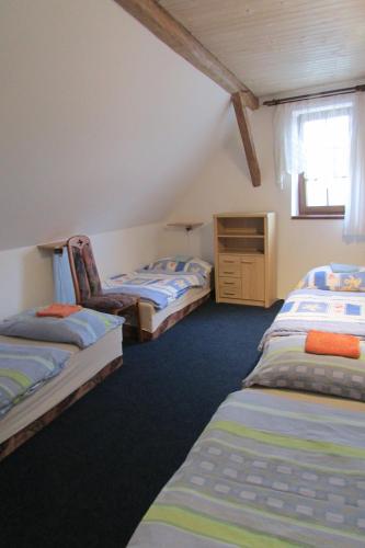 a bedroom with three beds and a dresser in it at Privát u koní in Úherce