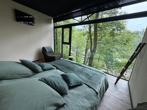 a bedroom with a large bed and a large window at Olivine 12 in La-Roche-en-Ardenne