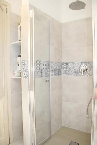 a shower with a glass door in a bathroom at Mediterranean Sea Shell Pool House in Budoni